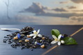 Tea leaves and flowers on a dark surface with a blurred natural background
