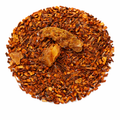 Dried rooibos tea leaves with ginger pieces on a white background